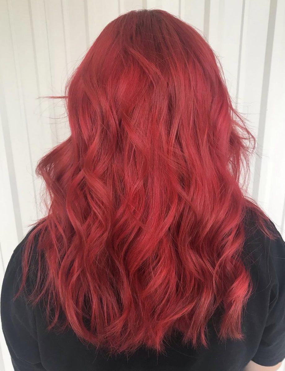 Vivid red hair color with curled waves